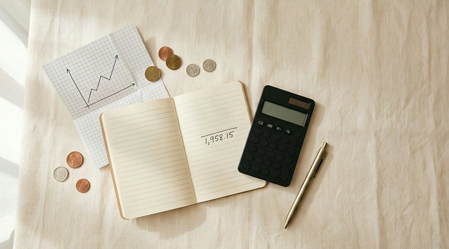 caculadora, caderno, caneta e moedas